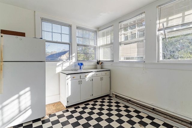 kitchen featuring white cabinets, white fridge, and a baseboard radiator