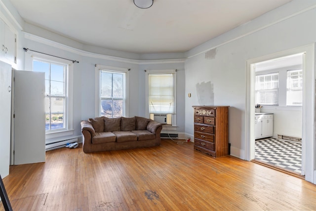 unfurnished living room featuring cooling unit, light hardwood / wood-style flooring, and a baseboard radiator