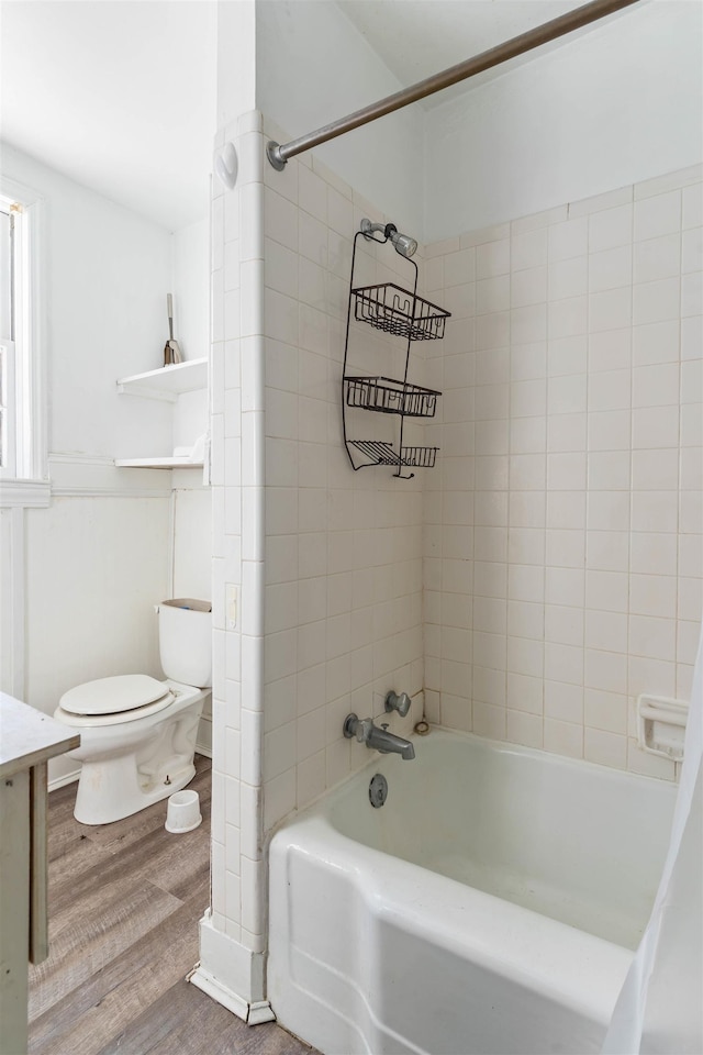 full bathroom with hardwood / wood-style floors, tiled shower / bath combo, toilet, and vanity