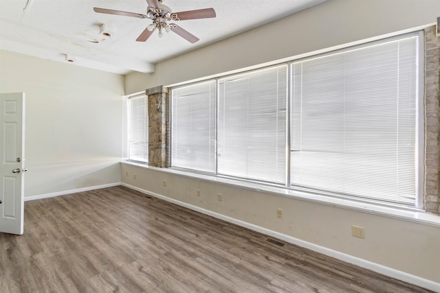 spare room featuring ceiling fan, wood-type flooring, and a textured ceiling