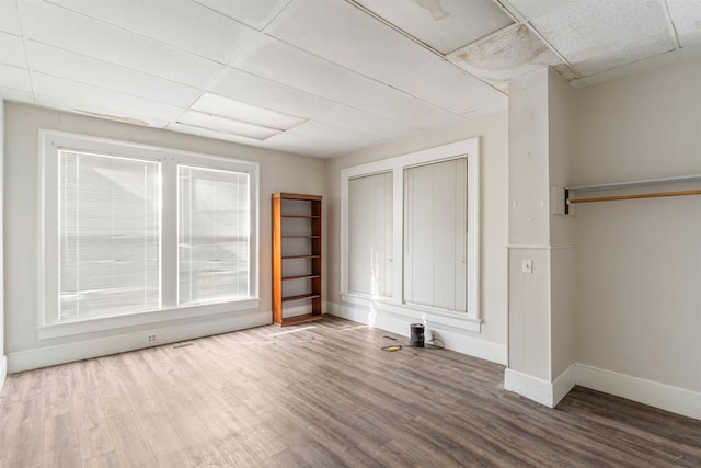 unfurnished bedroom featuring a paneled ceiling and wood-type flooring