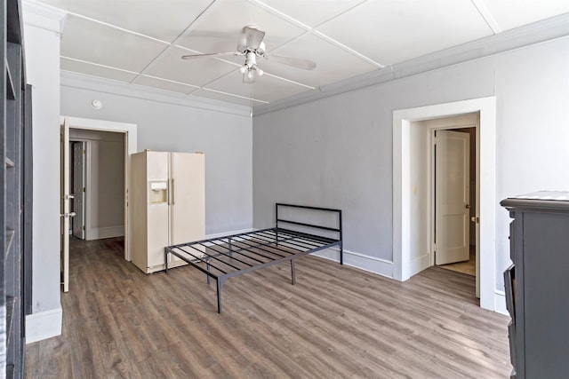 bedroom featuring ceiling fan, wood-type flooring, white refrigerator with ice dispenser, and crown molding