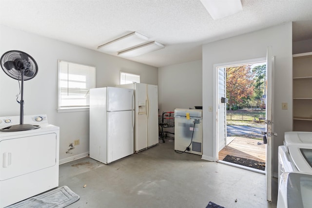 laundry room featuring a textured ceiling, a wealth of natural light, and washing machine and clothes dryer