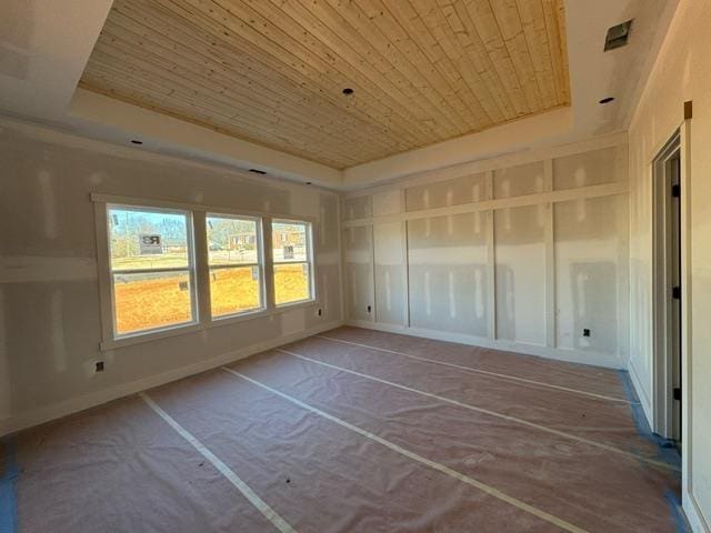 unfurnished sunroom featuring wood ceiling and a tray ceiling