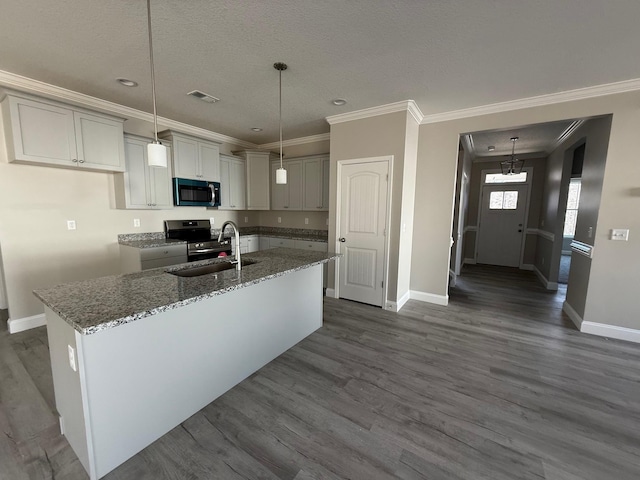 kitchen with sink, crown molding, decorative light fixtures, an island with sink, and stone counters