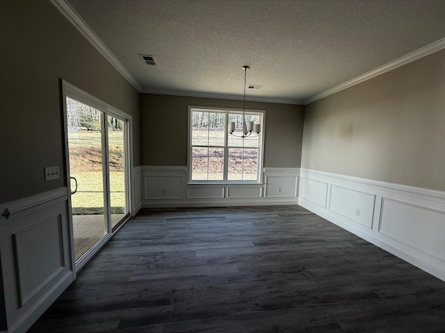 unfurnished dining area with a notable chandelier, dark wood-type flooring, ornamental molding, and a textured ceiling