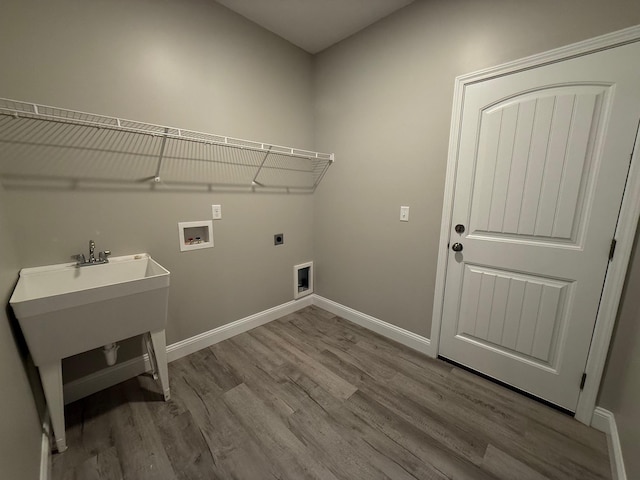 laundry area with sink, hookup for an electric dryer, hookup for a washing machine, and light wood-type flooring