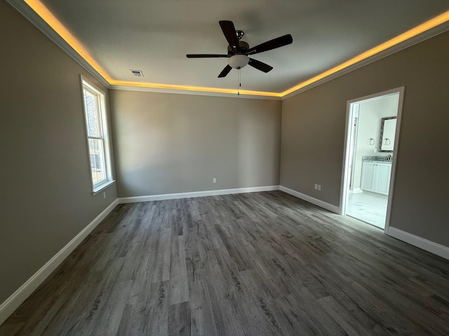 empty room with crown molding, ceiling fan, and dark hardwood / wood-style flooring