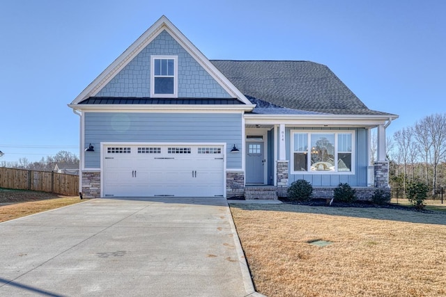 craftsman inspired home with a garage and a front lawn