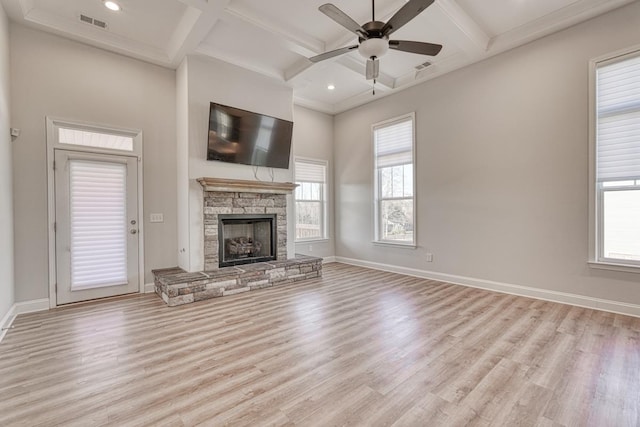 unfurnished living room with a healthy amount of sunlight, light wood-type flooring, and coffered ceiling