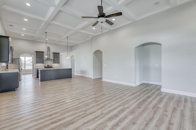 unfurnished living room featuring coffered ceiling, ceiling fan, sink, beam ceiling, and light hardwood / wood-style floors