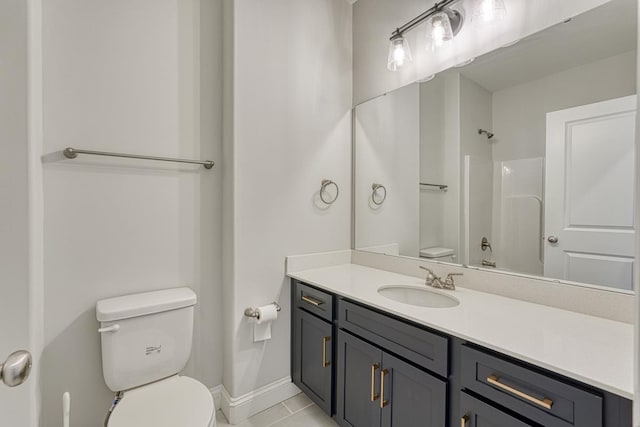 bathroom with toilet, vanity, and tile patterned floors