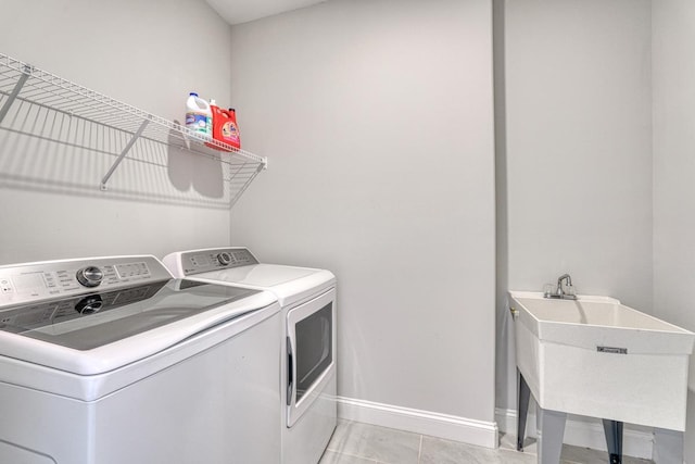 washroom with separate washer and dryer, sink, and light tile patterned floors