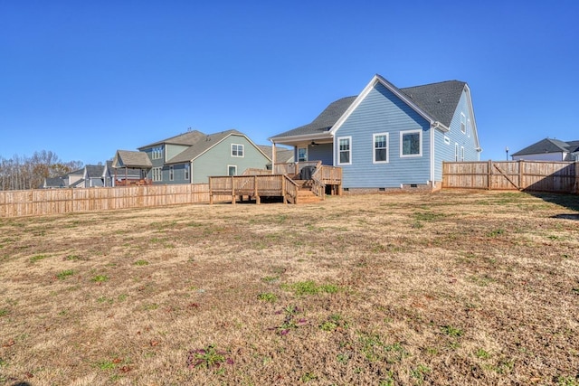 rear view of house featuring a lawn and a wooden deck