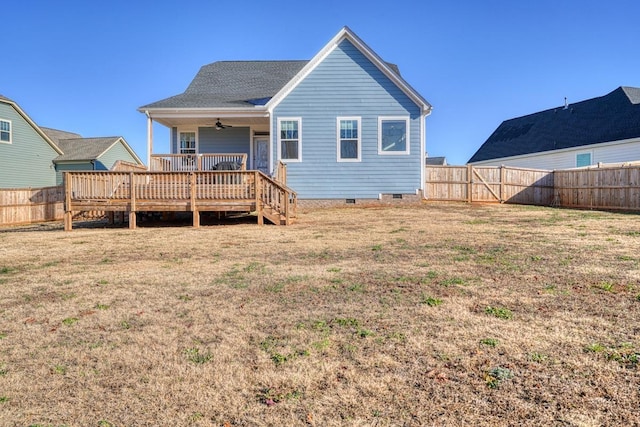 rear view of house featuring ceiling fan, a lawn, and a wooden deck