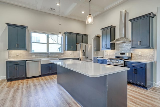 kitchen featuring tasteful backsplash, wall chimney exhaust hood, coffered ceiling, and appliances with stainless steel finishes