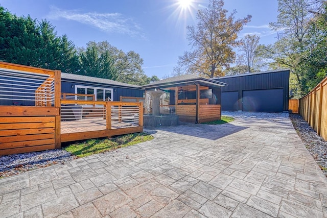 exterior space with a garage, an outbuilding, and a wooden deck