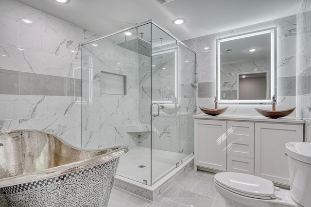 bathroom with vanity, toilet, tile walls, and walk in shower