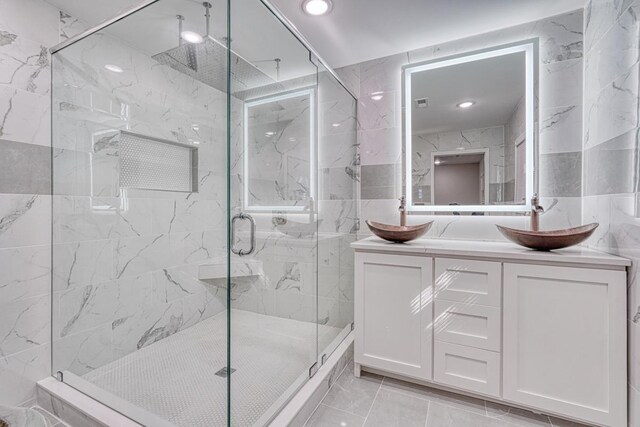 bathroom featuring vanity, tile walls, and a shower with shower door