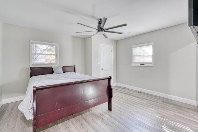 bedroom with multiple windows, ceiling fan, and light wood-type flooring