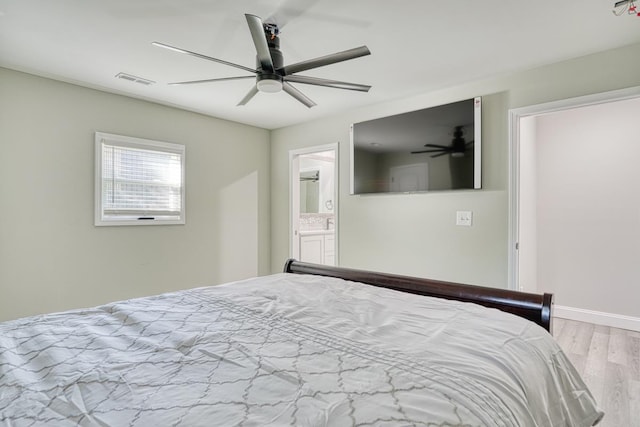 bedroom with ceiling fan, ensuite bath, and light hardwood / wood-style flooring