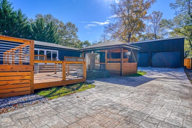 exterior space featuring a garage, an outdoor structure, and a wooden deck