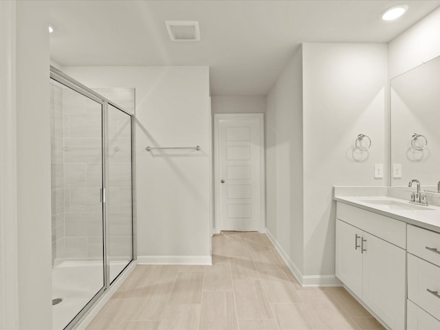 bathroom featuring vanity and a shower with shower door