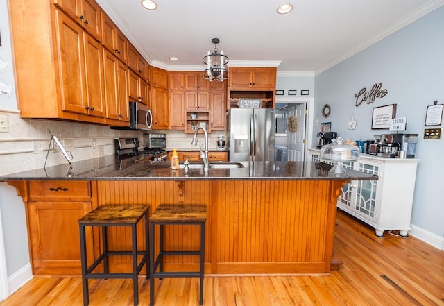 kitchen featuring stainless steel appliances, light hardwood / wood-style flooring, crown molding, and sink