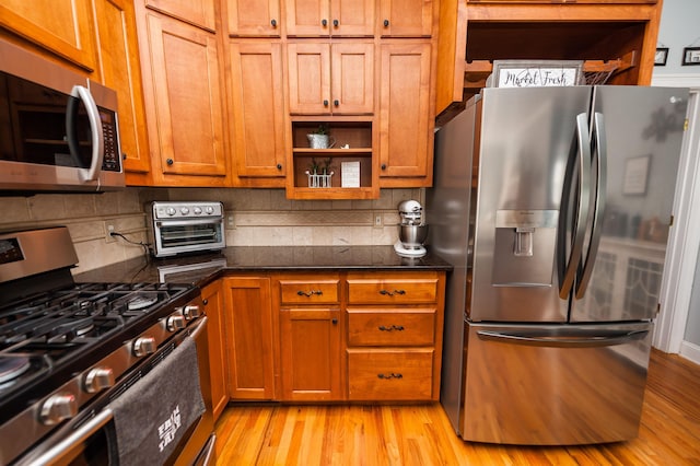 kitchen featuring decorative backsplash, stainless steel appliances, and light hardwood / wood-style floors