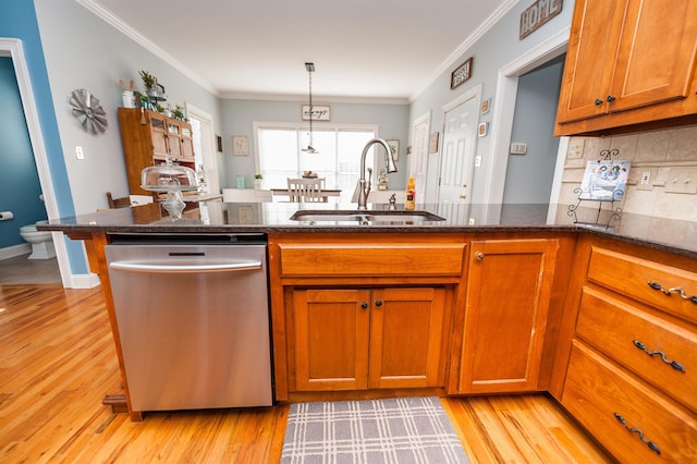 kitchen featuring dishwasher, light wood-type flooring, crown molding, and sink