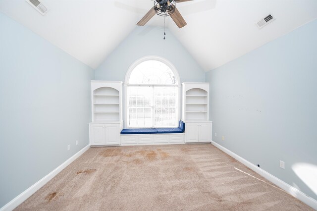 carpeted spare room with ceiling fan and vaulted ceiling