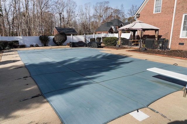 view of pool with a gazebo and a diving board