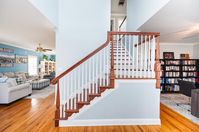 stairway with hardwood / wood-style floors, ceiling fan, and crown molding