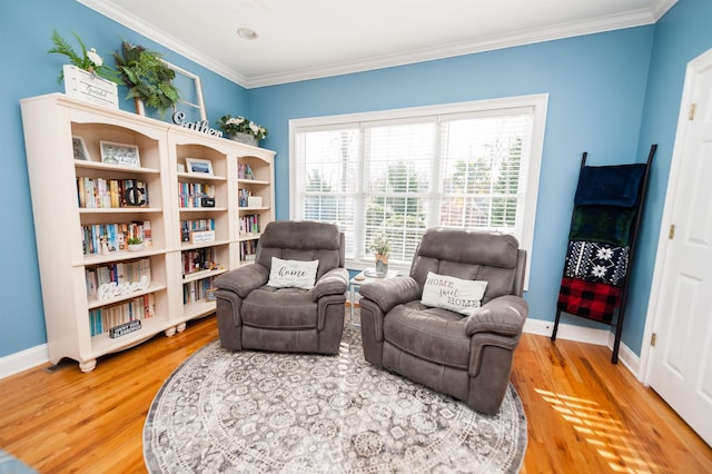 living area with wood-type flooring and crown molding