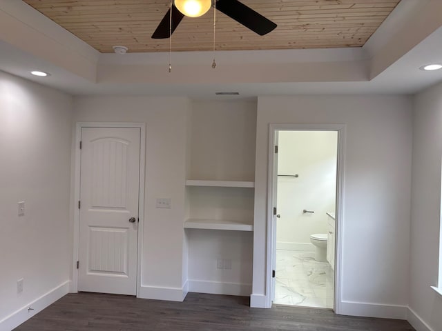 unfurnished bedroom with a raised ceiling, ensuite bath, ceiling fan, and wooden ceiling