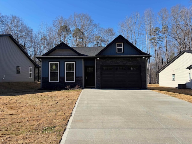 craftsman inspired home with board and batten siding, stone siding, driveway, and a garage