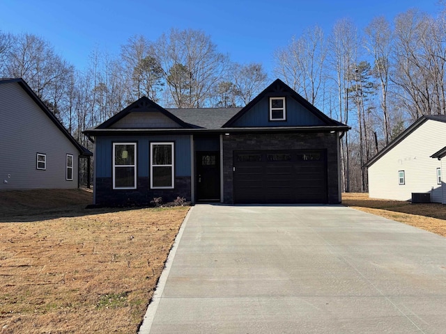 craftsman inspired home featuring driveway, stone siding, board and batten siding, and an attached garage