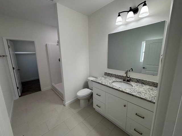 bathroom featuring toilet, a shower stall, vanity, and baseboards