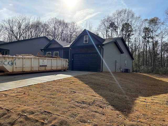 rear view of house with a garage and central AC