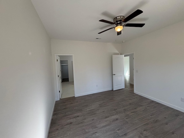 unfurnished bedroom with ceiling fan, dark wood finished floors, visible vents, and baseboards