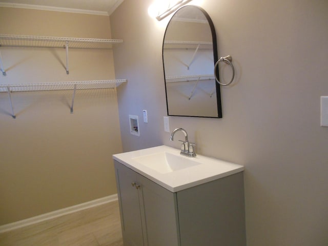 bathroom with hardwood / wood-style flooring, vanity, and ornamental molding