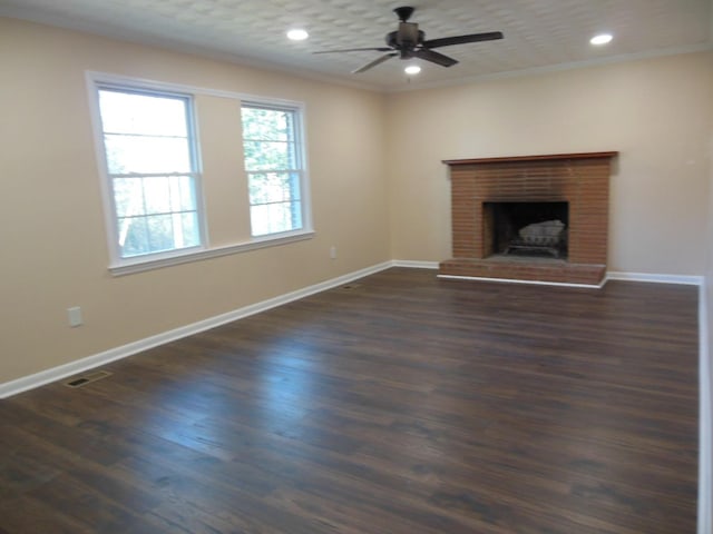 unfurnished living room with a fireplace, dark hardwood / wood-style floors, ceiling fan, and crown molding