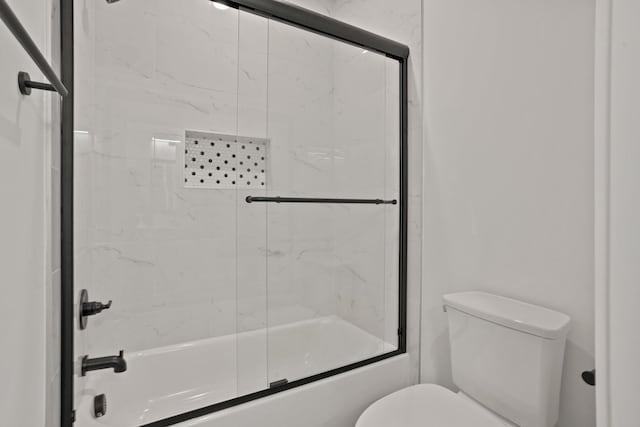 bathroom with shower / bath combination with glass door and toilet