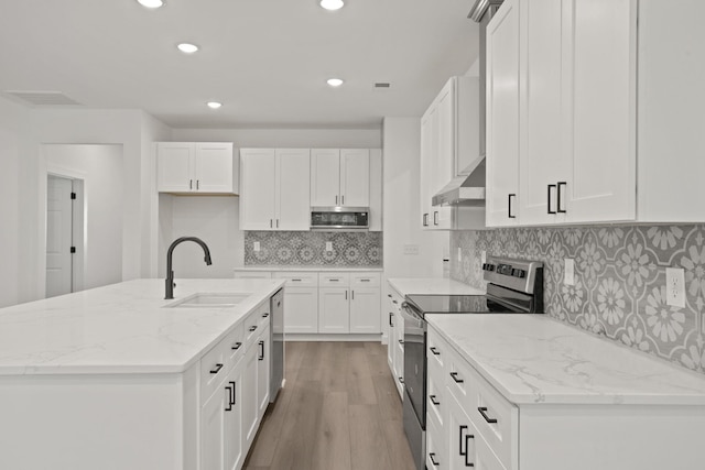 kitchen with white cabinets, stainless steel appliances, extractor fan, and an island with sink