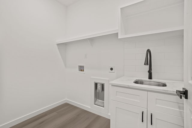 washroom with cabinets, washer hookup, electric dryer hookup, sink, and hardwood / wood-style flooring