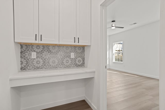 interior details featuring hardwood / wood-style floors, tasteful backsplash, and ceiling fan