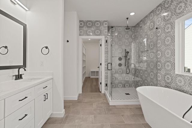 bathroom with tile patterned flooring, vanity, and plus walk in shower