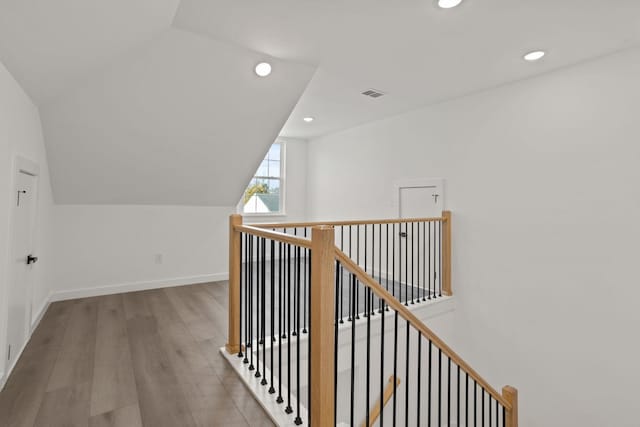 hall featuring hardwood / wood-style floors and vaulted ceiling