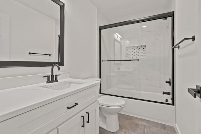 full bathroom with tile patterned flooring, vanity, toilet, and shower / bath combination with glass door