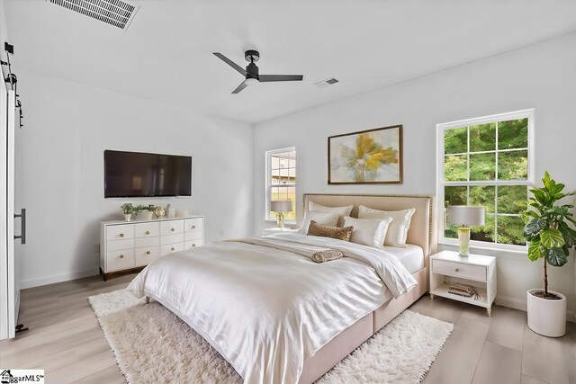 bedroom featuring multiple windows, ceiling fan, and light hardwood / wood-style floors